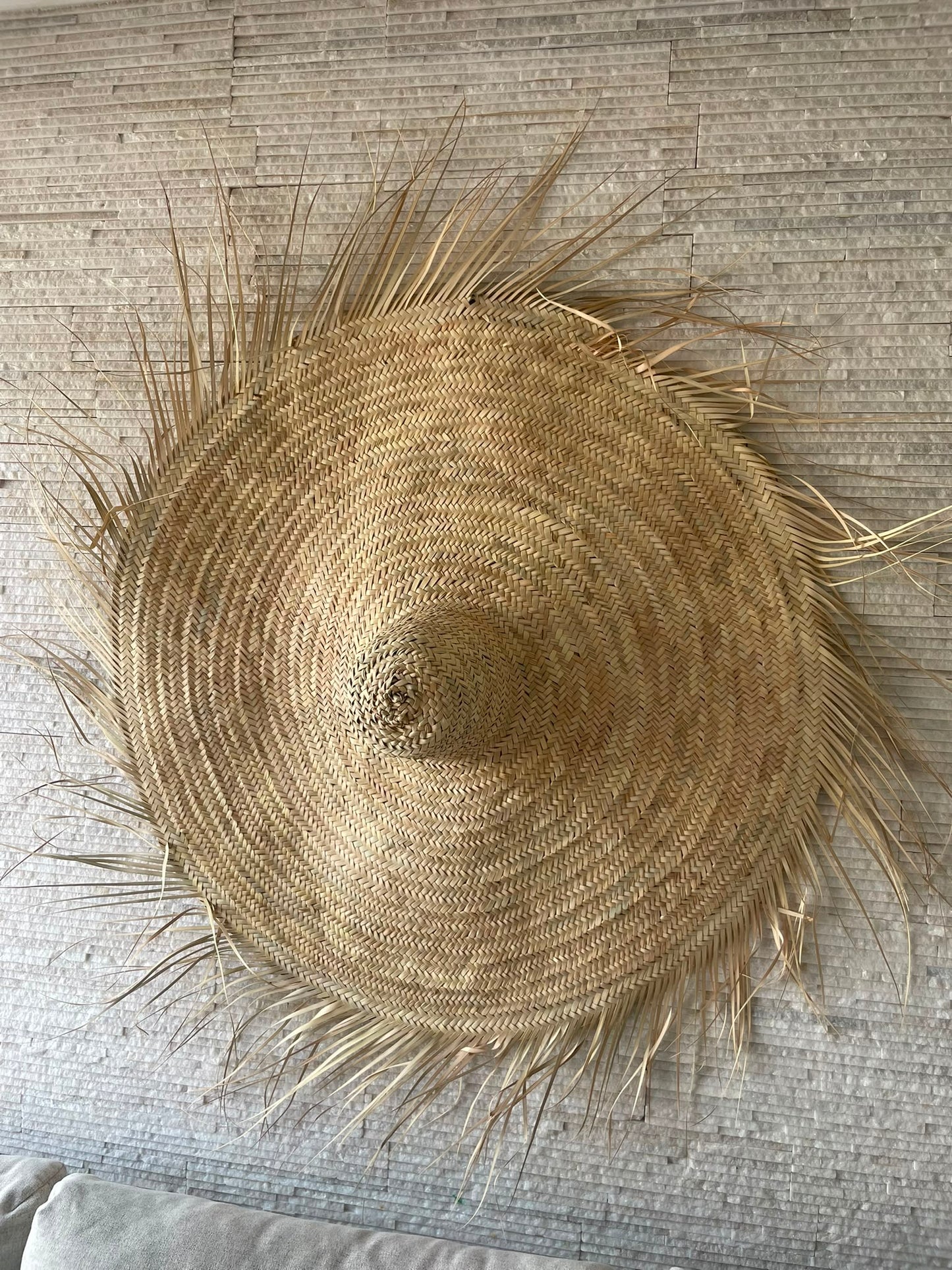 Chapeau mural artisanal en feuilles de palmier séchées
