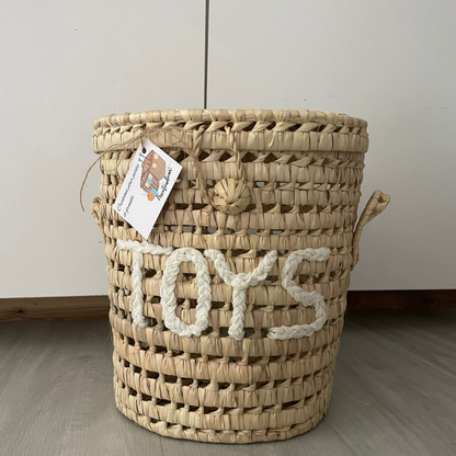 Panier de rangement en feuille de palmiers séchées avec inscription TOYS en laine blanche pour chambre enfant